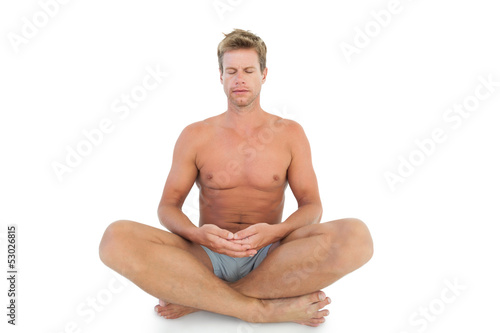 Man with eyes closed meditating on the floor