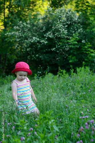 cute little girl playing in the green field