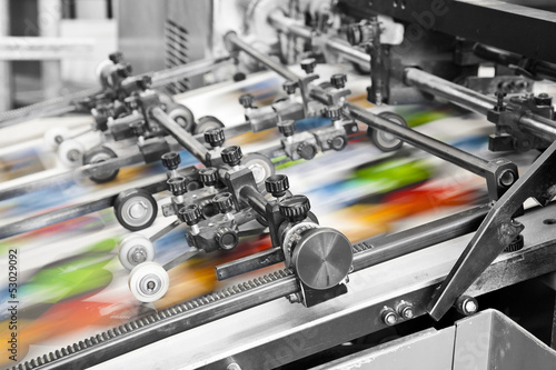 Photo Close up of an offset printing machine during production