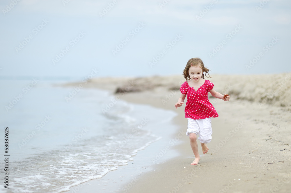 Adorable little girl on a sandy beach