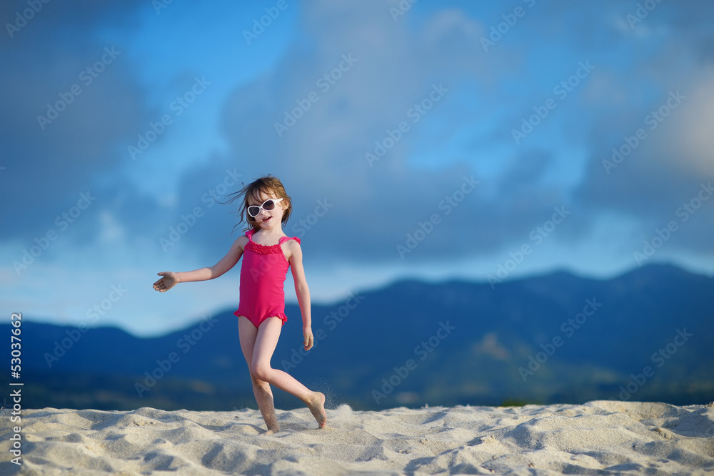 Adorable little girl playing on a sandy beach Adorable little girl playing on a sandy beach