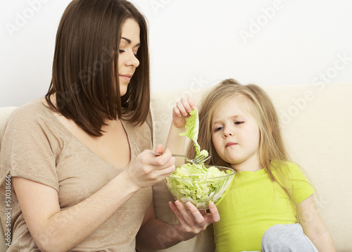 Mother feeds little girl