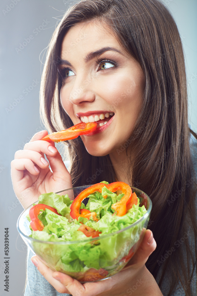 Woman eating green salad . Female model close up face studio is Woman eating green salad . Female model close up face studio is