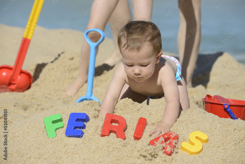 Baby playing with beach toys in the sand Baby playing with beach toys in the sand