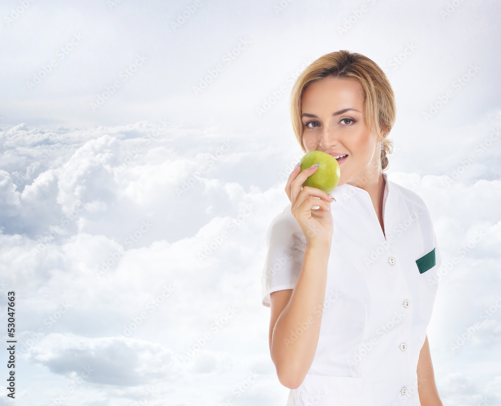 A young and attractive female doctor holding and apple