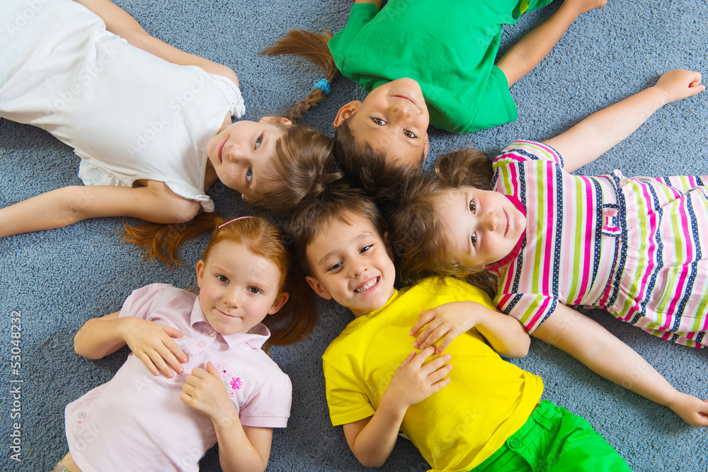 Cute little children lying on floor