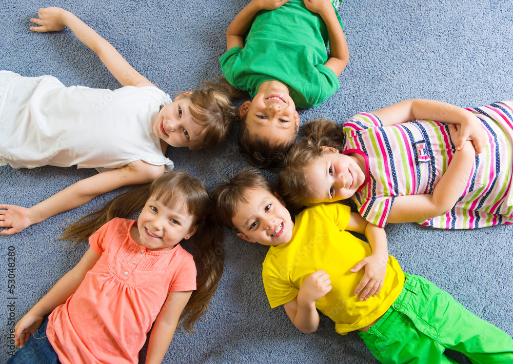 Cute little children lying on floor