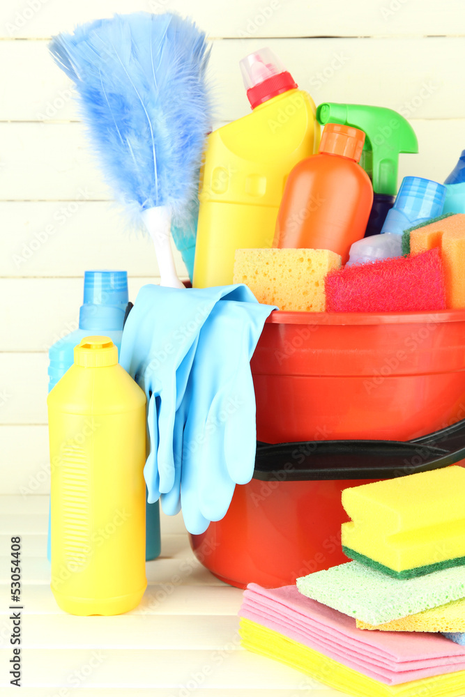 Cleaning items in bucket on white wooden background Cleaning items in bucket on white wooden background