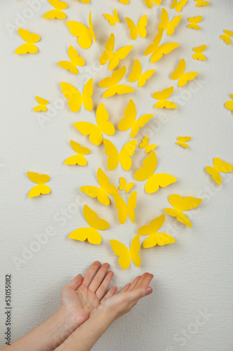 Paper yellow butterflies fly on wall in different directions