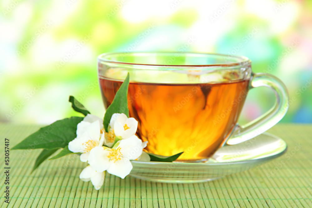 Cup of tea with jasmine, on bamboo mat, on bright background Cup of tea with jasmine, on bamboo mat, on bright background