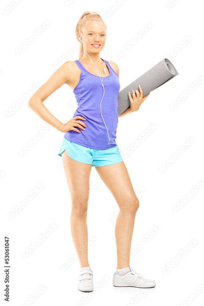 Full length portrait of a young female holding an exercising mat Full length portrait of a young female holding an exercising mat