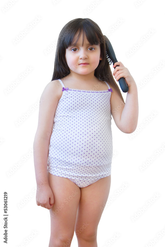 The girl in an undershirt and shorts combs hair The girl in an undershirt and shorts combs hair