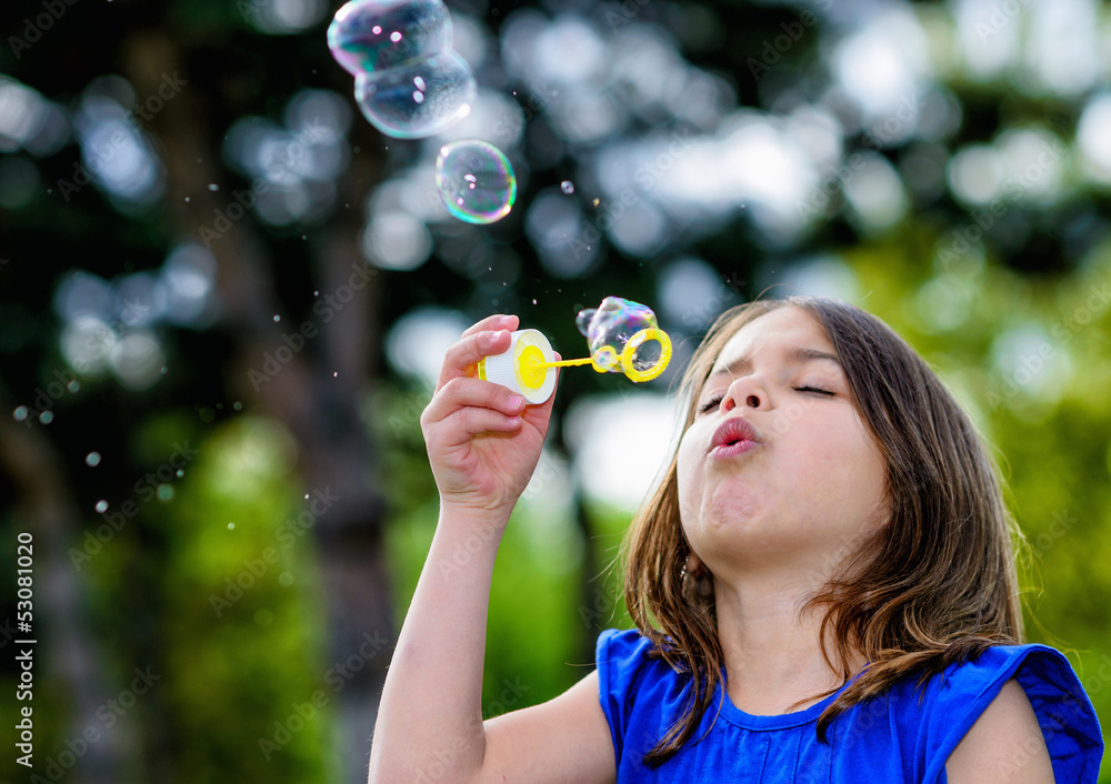beautiful child blowing bubbles