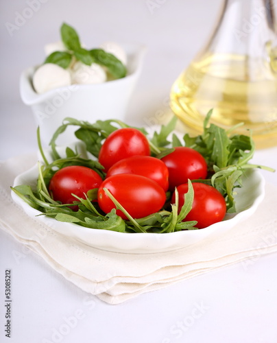 Ingredients for salad with arugula, tomatoes and mozzarella mini