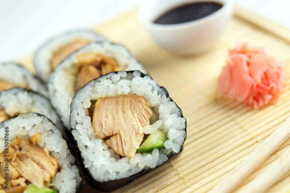 Obraz premium Roladki sushi z kurczaka teriyaki z ogórkiem, imbirem i sosem sojowym