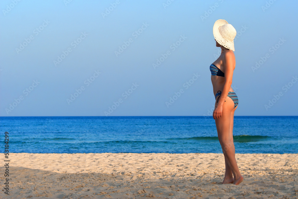 Woman on the beach with white hat