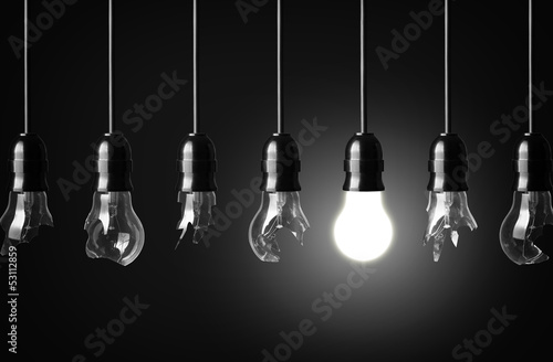 idea concept with broken bulbs and one glowing bulb