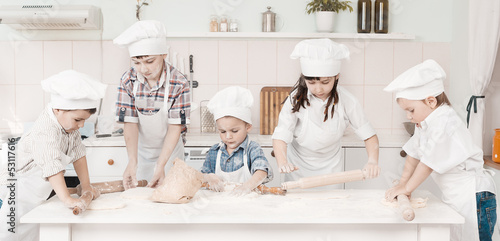 happy little chefs preparing dough in the kitchen with their