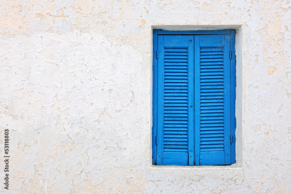 White house facade with blue shutters in Pyrgos