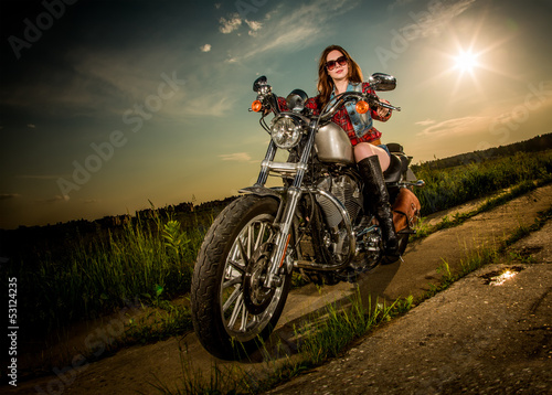 Fototapeta Naklejka Na Ścianę i Meble -  Biker girl sitting on motorcycle