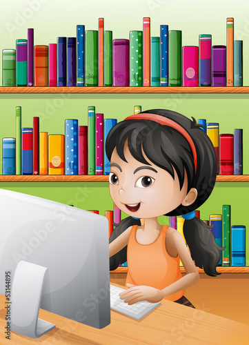 A young girl using the computer at the library