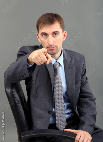 Young businessman  on grey ...