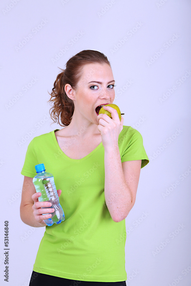 Beautiful young woman with bottle of water and apple Beautiful young woman with bottle of water and apple