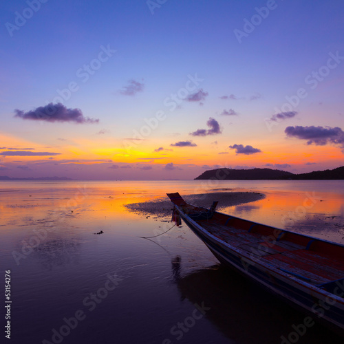 Sunset over sea with small wooden boat, Thailand