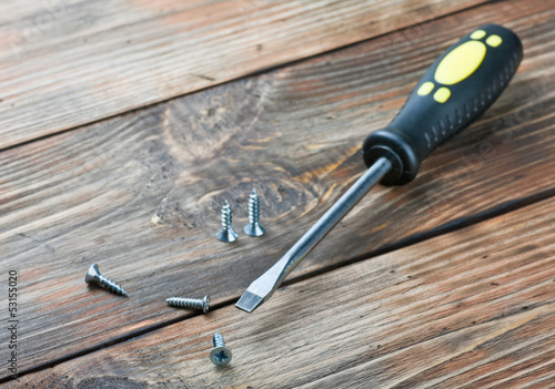 Photo screwdriver and screws on a wooden table