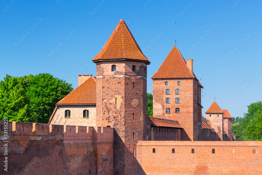 The wall and towers of Malbork castle in summer scenery, Poland