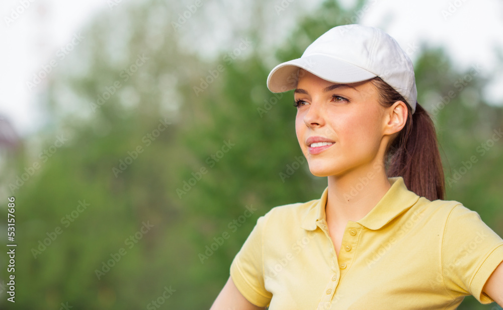 Portrait of a happy young sports woman wearing cap