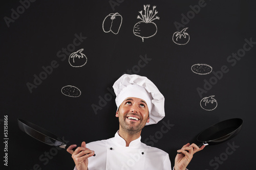 Handsome chef jugglery with vegetable