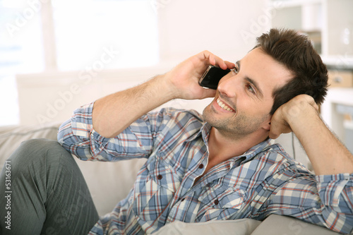 Young man at home talking on mobile phone