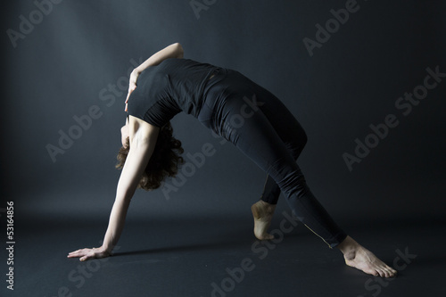 yoga posture wild thing pose variation on black background