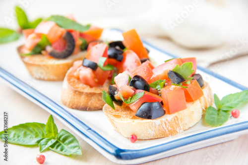 Classic Italian appetizer bruschetta with tomato, basil and blac