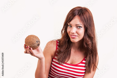 Beautiful smiling woman shows a coconut, copy space