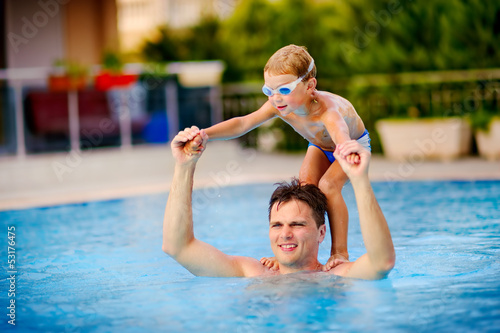 young swimmer boy on swim start at swimming pool ready for jump