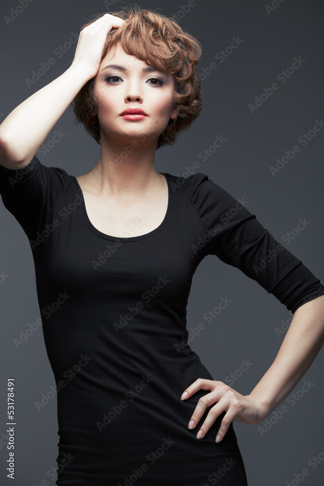 Young woman portrait standing against studio background. Young woman portrait standing against studio background.
