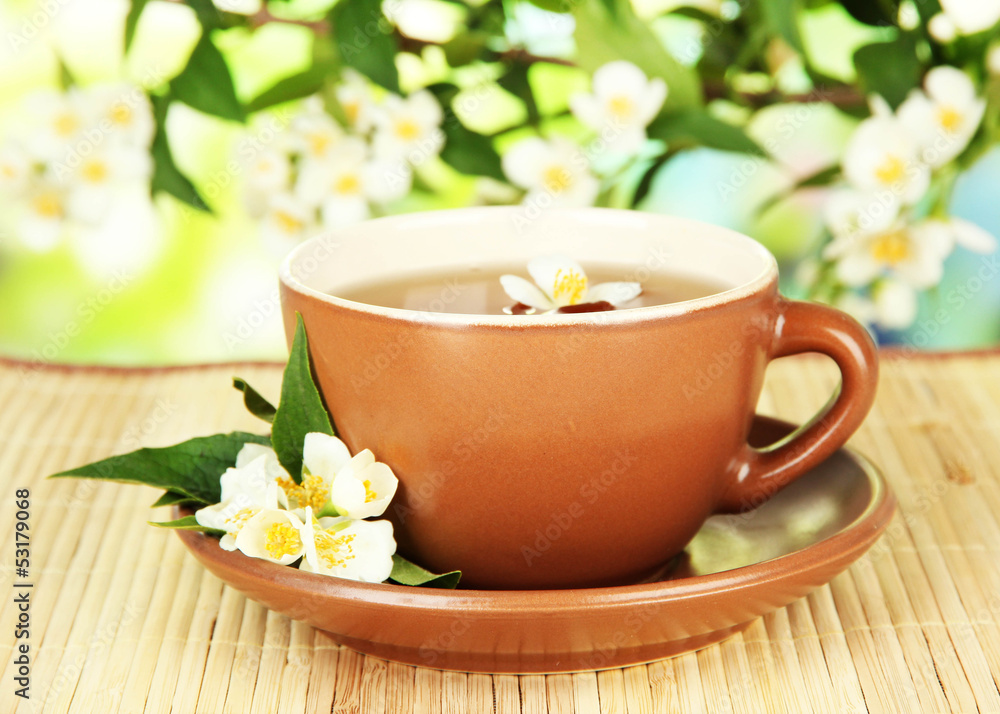 Cup of tea with jasmine, on bamboo mat, on bright background Cup of tea with jasmine, on bamboo mat, on bright background