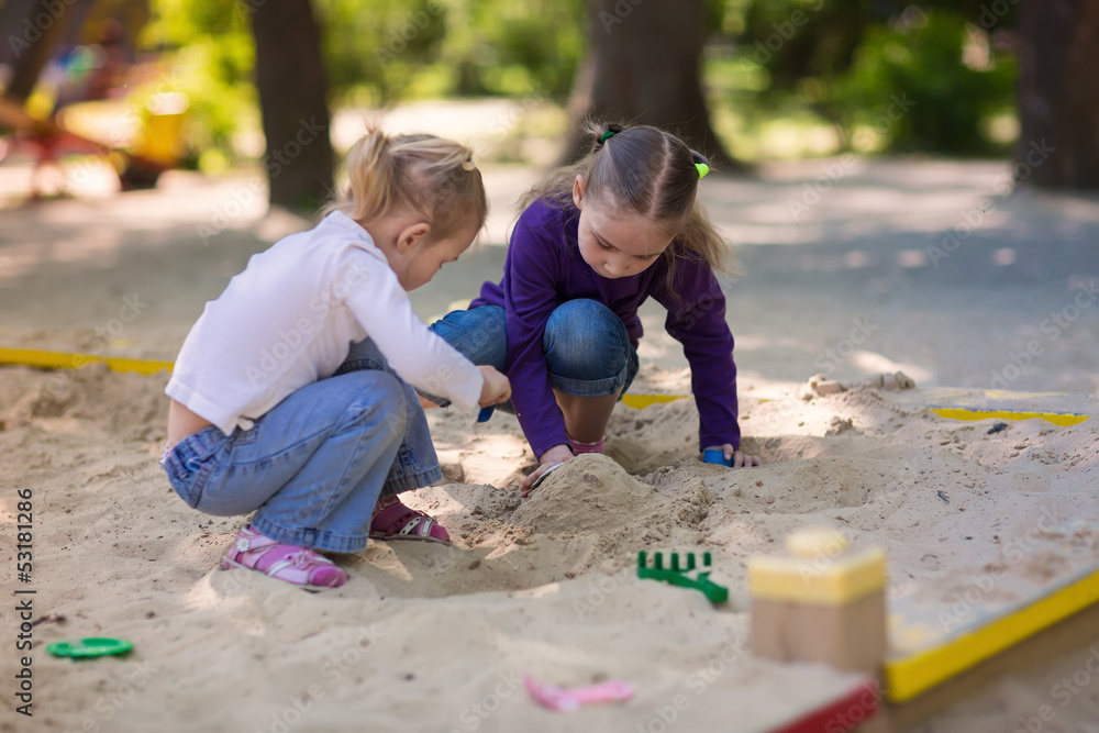 Happy little girls playing in a sandbox Happy little girls playing in a sandbox