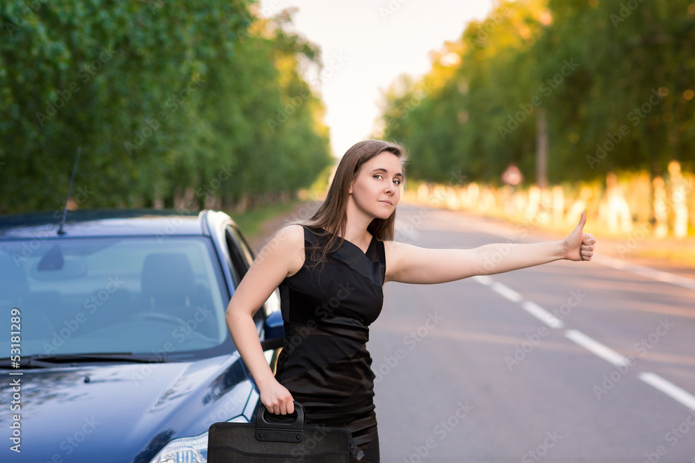 Fototapeta premium Beautiful businesswoman near her car trying to stop another car