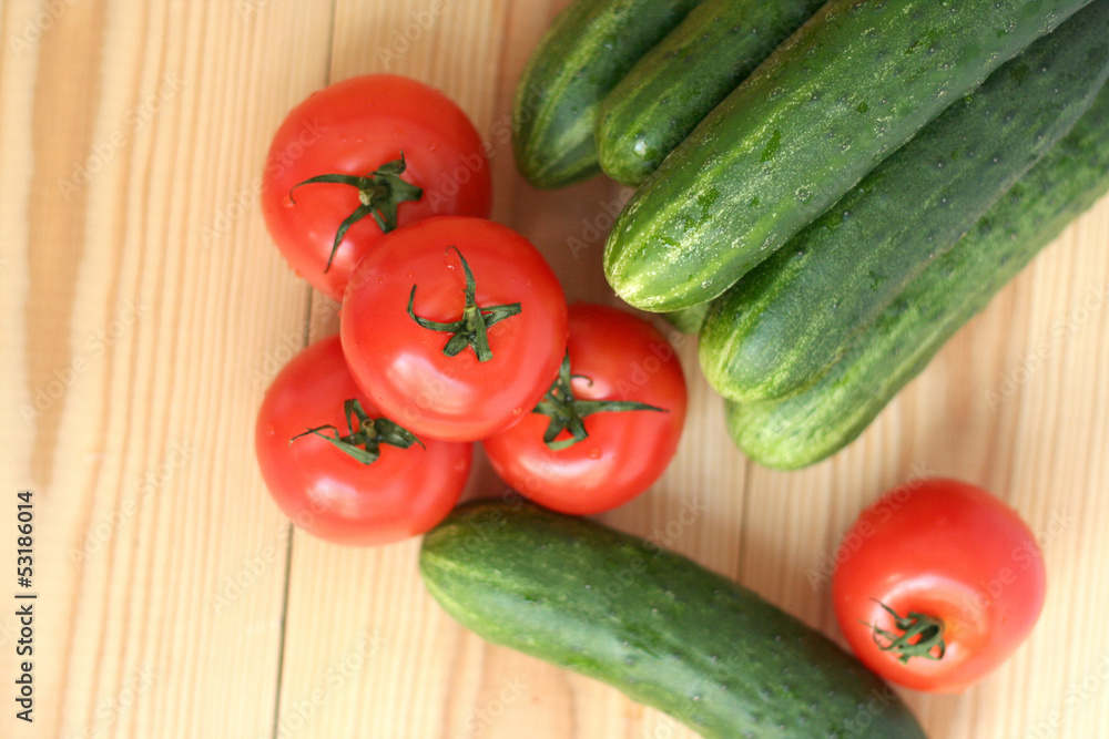 fresh tomatoes and cucumbers on a wooden table fresh tomatoes and cucumbers on a wooden table