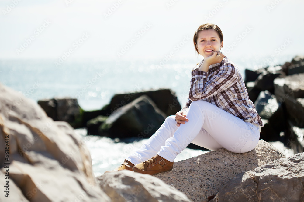 woman  on stone at sea coast