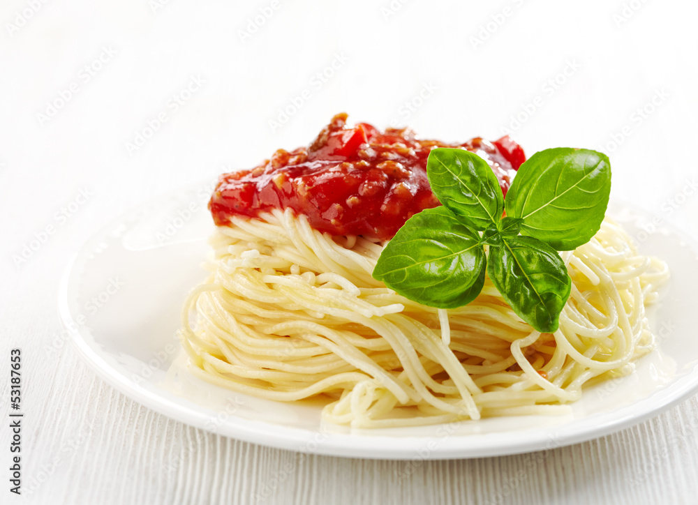 Spaghetti bolognese and green basil leaf on white plate Spaghetti bolognese and green basil leaf on white plate