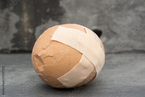 Broken healthcare concept image of plaster on egg photo