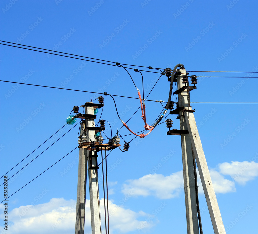 two electricity poles with a blue sky as background two electricity poles with a blue sky as background