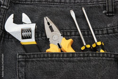 tools in a black jean back pocket
