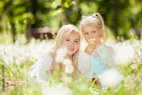 Mother and daughter eating ice-cream in the park