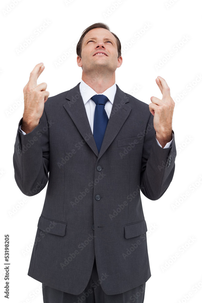 Businessman with fingers crossed is looking up Businessman with fingers crossed is looking up