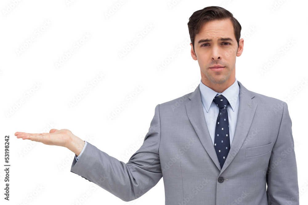 Serious businessman with open hand looking at the camera Serious businessman with open hand looking at the camera